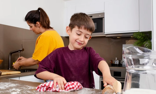 Image of a boy child and his mother were engaged in cleaning the kitchen.