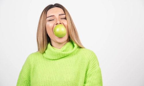 Young woman eating a fresh green apple
