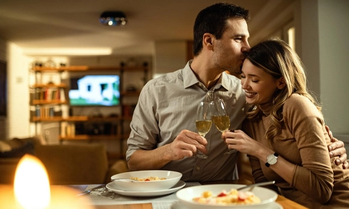Couple enjoying a romantic dinner and raising a toast
