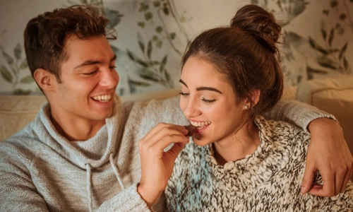 Man feeding chocolate to his partner during a sweet moment