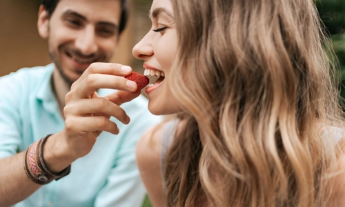 Smiling couple sharing strawberries together