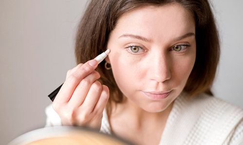 Young-woman-applying-white-eyeliner