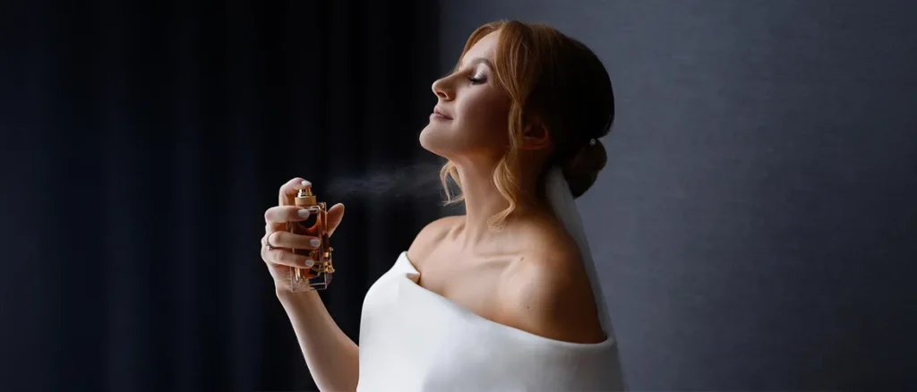 applying perfume to her neck before getting dressed