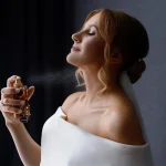 applying perfume to her neck before getting dressed