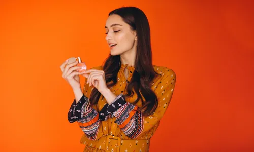 Woman in a yellow dress applying perfume correctly