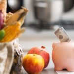 A piggy bank with a bag of vegetables and fruits.