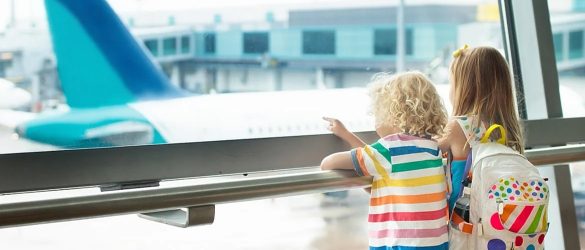 Children conversing by pointing at planes at the airport.