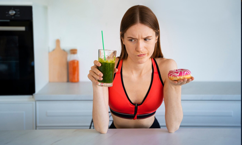 A-woman-holding-a-smoothie-and-donuts