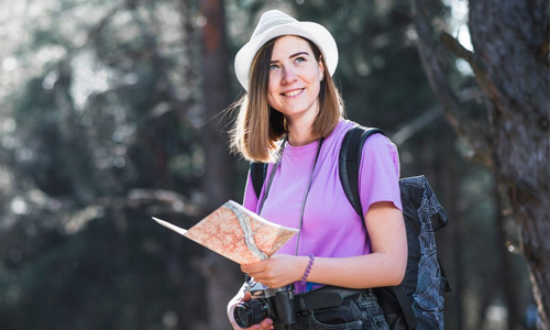 A-woman-standing-in-the-forest-with-a-map