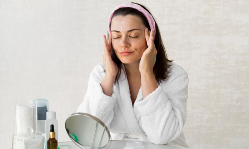 A woman is applying cream for healthy skin