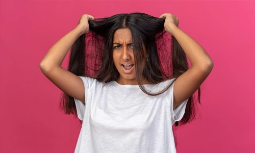 Young girl in white t-shirt looking frustrated pulling her hair going wild