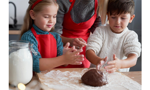 Two kids making homemade chocolates with their parent