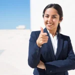Happy young Professional woman expressing confidence showing thumbs up sign.