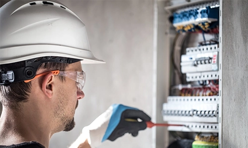 Image of a electrician working on an electrical circuit board