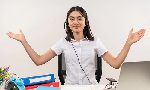 Customer service representative wearing a headset and sitting at a desk with office supplies