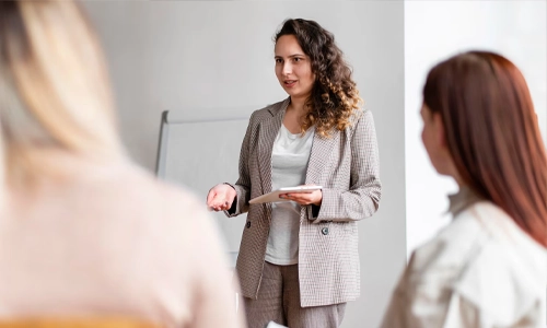 A woman talking in two women in a meeting in office.